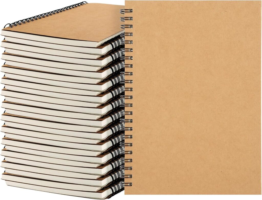 A stack of thirteen spiral-bound notebooks with plain brown covers is shown next to one standing notebook facing forward, also with a plain brown cover.